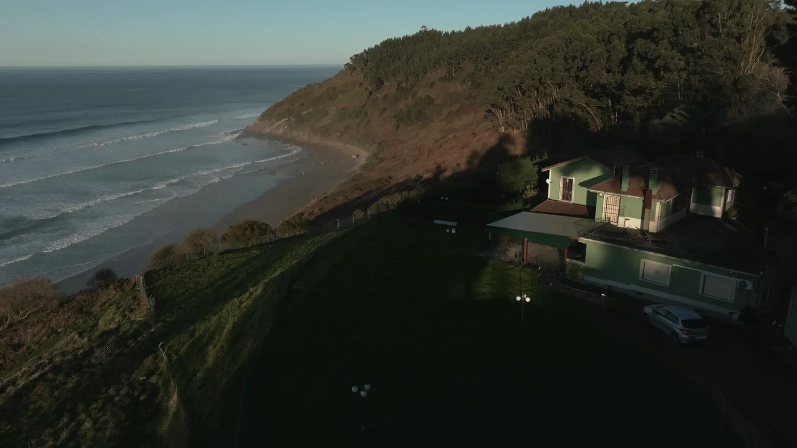 Aerial view of the house on the cliff and the Caravia coast at sunrise